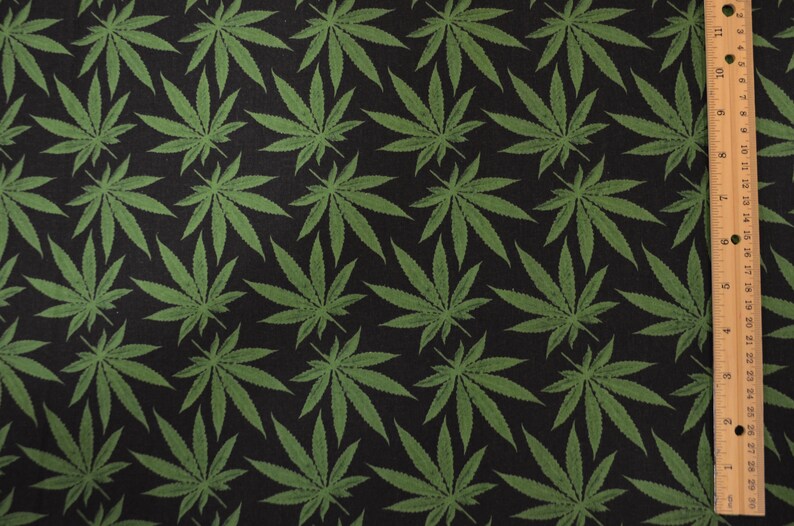 May include: Black fabric with a repeating pattern of green cannabis leaves.