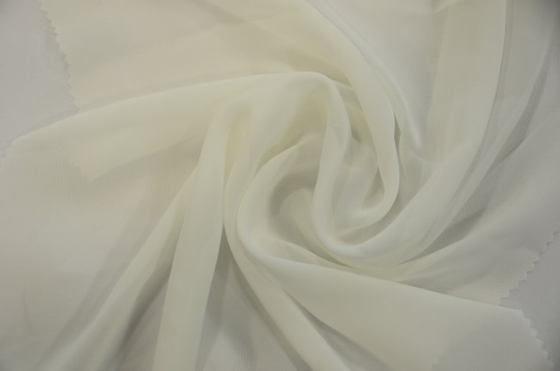 May include: A piece of white sheer fabric, folded and draped, showcasing its soft and delicate texture.
