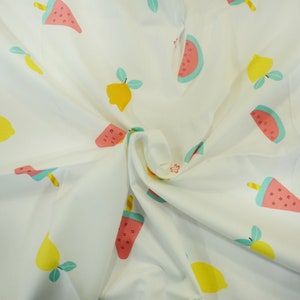 May include: White fabric with a repeating pattern of pink and green watermelon slices and yellow lemons with green leaves.
