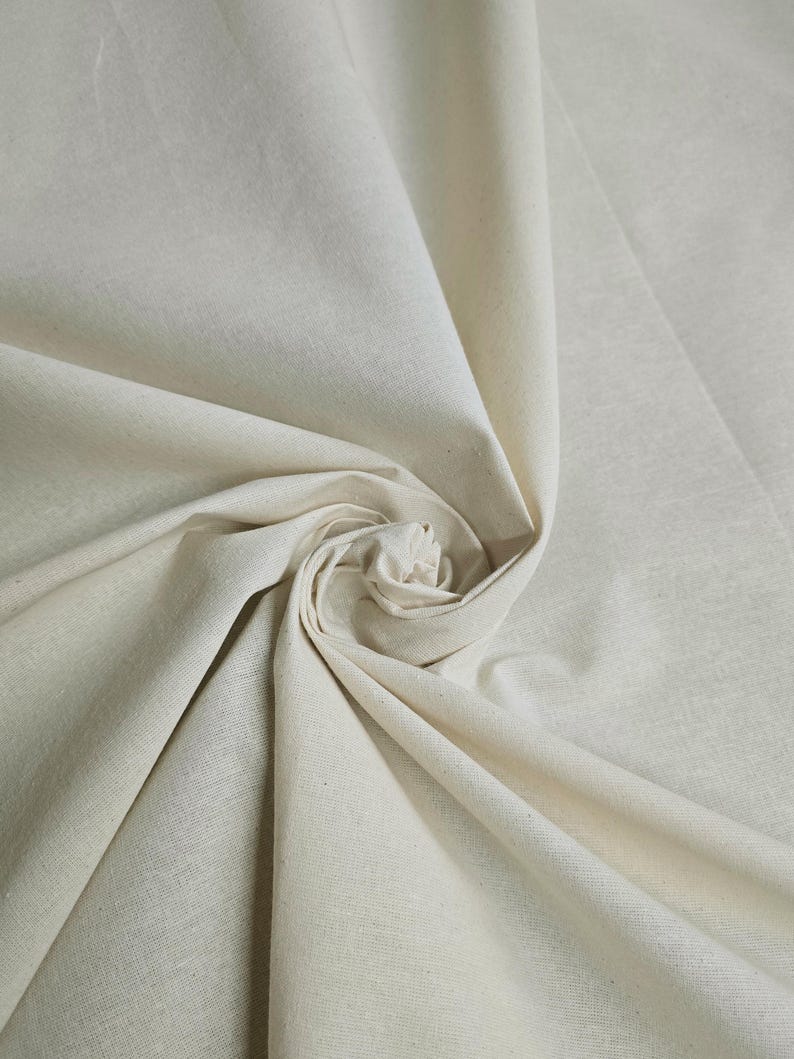 May include: A close-up of a natural white cotton fabric, showing its texture and drape.