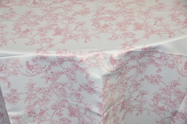 May include: White tablecloth with a pink floral pattern featuring stylised birds and trees.