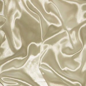 May include: A close-up of a smooth, ivory-colored satin fabric with soft, flowing folds and wrinkles.