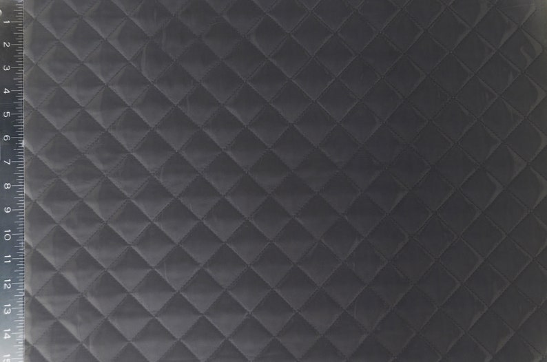 May include: Black quilted fabric with a diamond pattern. The fabric is measured in inches.