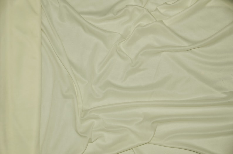 Puede incluir: Primer plano de una tela lisa de color marfil con pliegues y arrugas suaves.
