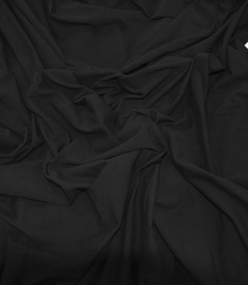 Peut inclure: Tissu noir avec une texture lisse et douce. Le tissu est drap&eacute; et pli&eacute;, montrant sa flexibilit&eacute; et son drap&eacute;.