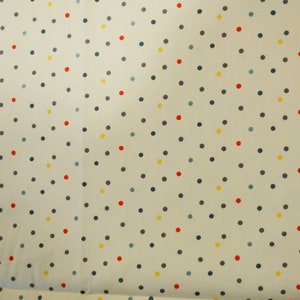May include: A white fabric with a repeating pattern of small, colorful polka dots. The dots are in shades of red, yellow, blue, and gray.