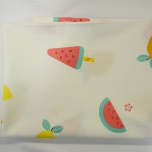 May include: White fabric with a repeating pattern of lemons, watermelon slices, and watermelon popsicles. The lemons are yellow with green leaves. The watermelon slices are red and green. The watermelon popsicles are red and green with a yellow stick.