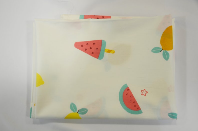 May include: White fabric with a repeating pattern of lemons, watermelon slices, and watermelon popsicles. The lemons are yellow with green leaves. The watermelon slices are red and green. The watermelon popsicles are red and green with a yellow stick.