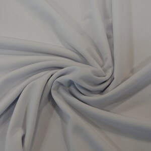 May include: A close-up of a smooth, light gray fabric with a soft, drapey texture.