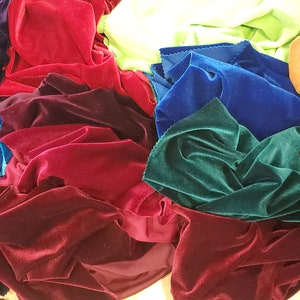 May include: A collection of velvet fabric swatches in various colours, including teal, blue, green, burgundy, red, brown, gold, and purple.