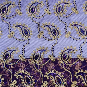 Może przedstawiać: Fioletowy i złoty materiał z wzorem paisley i fakturą. Materiał ma dwukolorowy wz&oacute;r z jaśniejszą fioletową warstwą g&oacute;rną i ciemniejszą fioletową warstwą dolną.