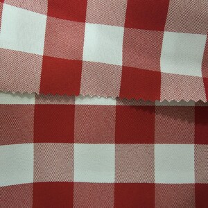 May include: Red and white checkered fabric with a woven texture. The fabric is folded in half, showing the pattern on both sides.
