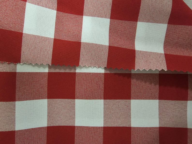 May include: Red and white checkered fabric with a woven texture. The fabric is folded in half, showing the pattern on both sides.