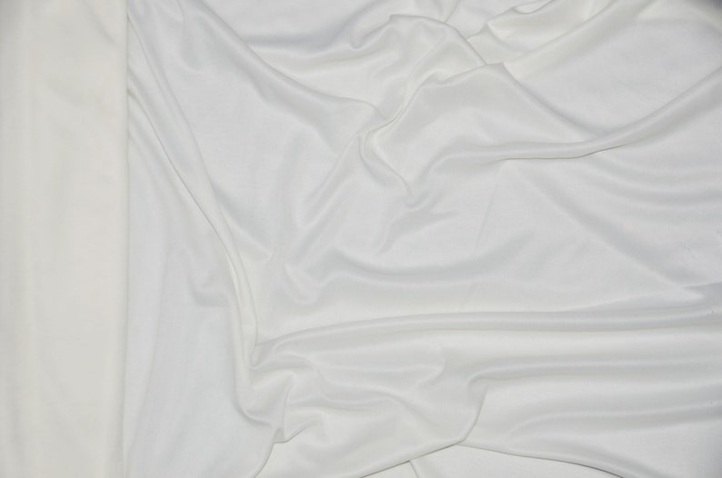 Puede incluir: Tela blanca con una textura suave y sedosa. La tela est&aacute; drapeada y doblada, creando pliegues y curvas suaves.