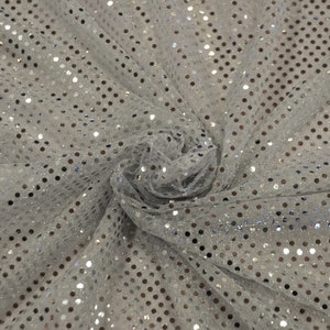 May include: White sheer fabric with silver sequins in a polka dot pattern.