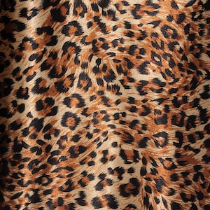 May include: A close-up of a brown and black leopard print fabric. The fabric has a shiny, satin-like finish.