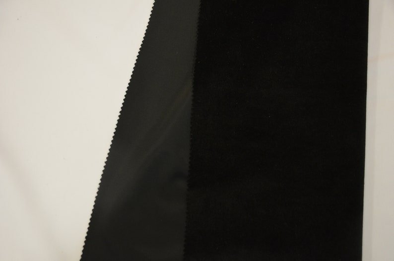 May include: Close-up of two black fabrics, one with a smooth satin finish and the other with a textured velvet finish.