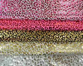 May include: Five different fabric swatches with a leopard print pattern. The swatches are in various colors, including pink, black, gold, and silver.