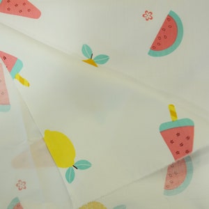 May include: White fabric with a repeating pattern of watermelon slices, lemons, and watermelon popsicles. The pattern is in shades of pink, yellow, green, and blue.