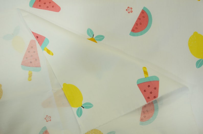 May include: White fabric with a repeating pattern of watermelon slices, lemons, and watermelon popsicles. The pattern is in shades of pink, yellow, green, and blue.