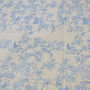 May include: White fabric with a blue floral pattern featuring elephants and monkeys. The pattern is repeated throughout the fabric.