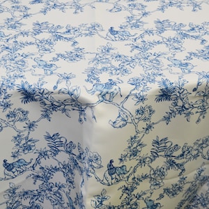 May include: White tablecloth with a blue and white floral pattern featuring elephants and monkeys. The pattern is reminiscent of a traditional toile design.