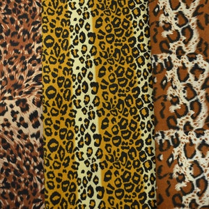 Op de afbeelding: Drie verschillende stofstalen met een luipaardprint. De stalen zijn bruin, oranje en wit met zwarte vlekken.