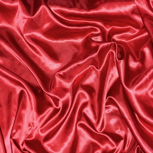 May include: A close-up of a smooth, red satin fabric with soft, flowing folds and wrinkles.