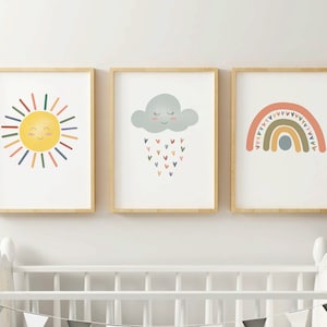 Könnte beinhalten: Drei gerahmte Drucke mit einer gelben Sonne mit einem lächelnden Gesicht, einer grauen Wolke mit einem lächelnden Gesicht, die Herzen regnet, und einem Regenbogen mit einer blauen Wolke in der Mitte.