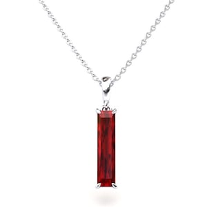 Puede incluir: Un collar de cadena de plata con un colgante con una piedra preciosa roja rectangular.