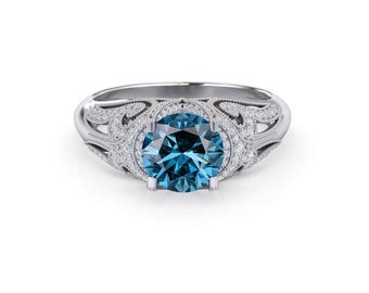 Könnte beinhalten: Ein silberner Ring mit einem blauen Edelstein, der von kleineren weißen Edelsteinen umgeben ist. Der Ring hat ein zartes, verziertes Design.