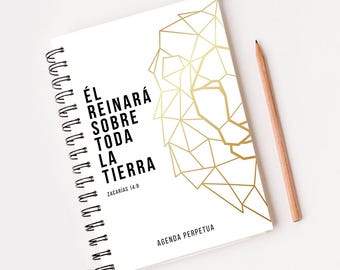 Pode incluir: Um caderno branco de espiral com um design de leão geométrico dourado e o texto "Él reinará sobre toda la tierra" com a referência bíblica "Zacarías 14:9" e o texto "Agenda Perpetua" na parte inferior.