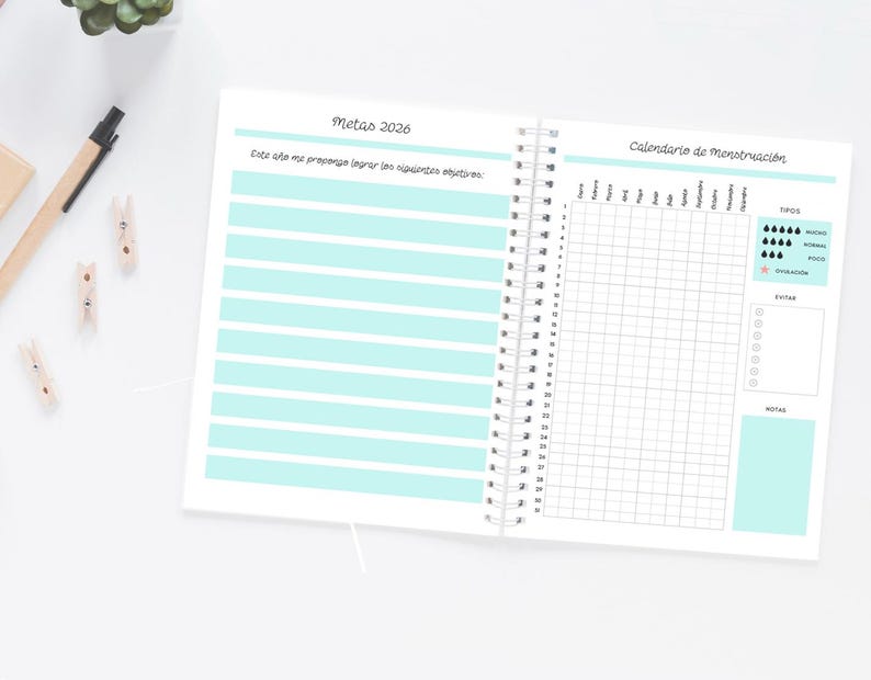 Pode incluir: Caderno aberto com encaderna&ccedil;&atilde;o em espiral, com linhas horizontais azuis claras na p&aacute;gina esquerda e uma grade de calend&aacute;rio na direita. O texto em espanhol inclui "Metas 2026" e "Calendario de menstruaci&oacute;n."