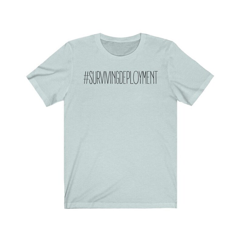 May include: A light blue t-shirt with the text "#SURVIVINGDEPLOYMENT" printed in black on the front.