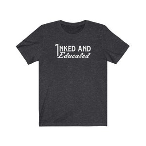 May include: A dark heather grey t-shirt with the text "INKED AND Educated" printed in white.