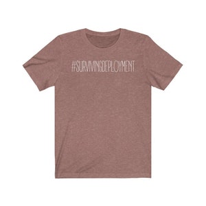 May include: A heather brown t-shirt with the text "#SURVIVINGDEPLOYMENT" printed in white on the front.