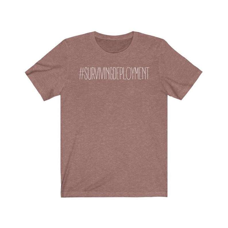 May include: A heather brown t-shirt with the text "#SURVIVINGDEPLOYMENT" printed in white on the front.