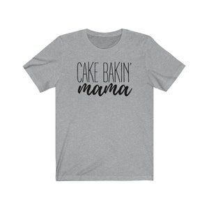 May include: Gray short-sleeved t-shirt with black text that reads "Cake Bakin' mama".