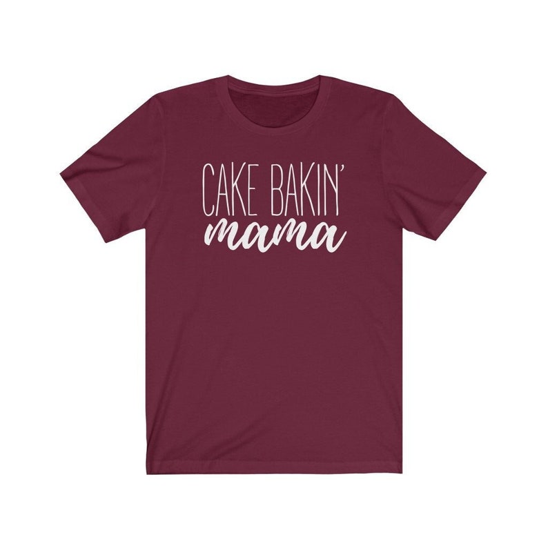 May include: A maroon short-sleeved t-shirt with the text "Cake Bakin' mama" in white.