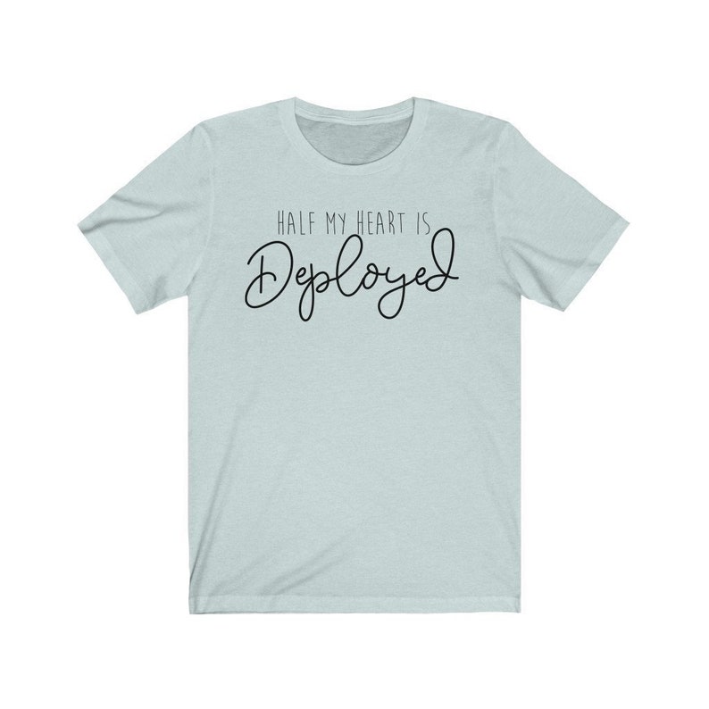 May include: A light blue t-shirt with the text "HALF MY HEART IS Deployed" in black.