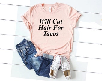 May include: A pink t-shirt with the text "Will Cut Hair For Tacos" printed in black.