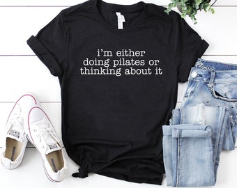May include: Black t-shirt with white text that reads "i'm either doing pilates or thinking about it".