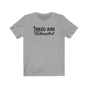 May include: A heather grey t-shirt with the text "INKED AND Educated" printed in black.