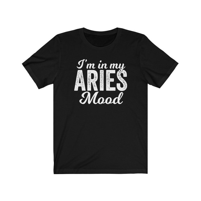以下が含まれることがあります： 白い文字で「I'm in my ARIES Mood」と書かれた黒いTシャツ。