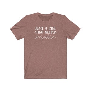 May include: A heather brown t-shirt with the text "Just a girl that needs insulin" in white.