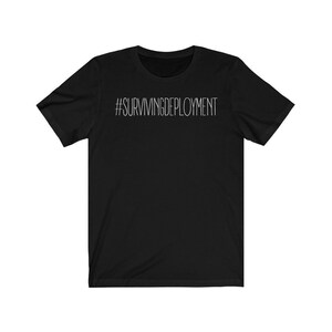May include: Black short-sleeved t-shirt with white text that reads "#SURVIVINGDEPLOYMENT".