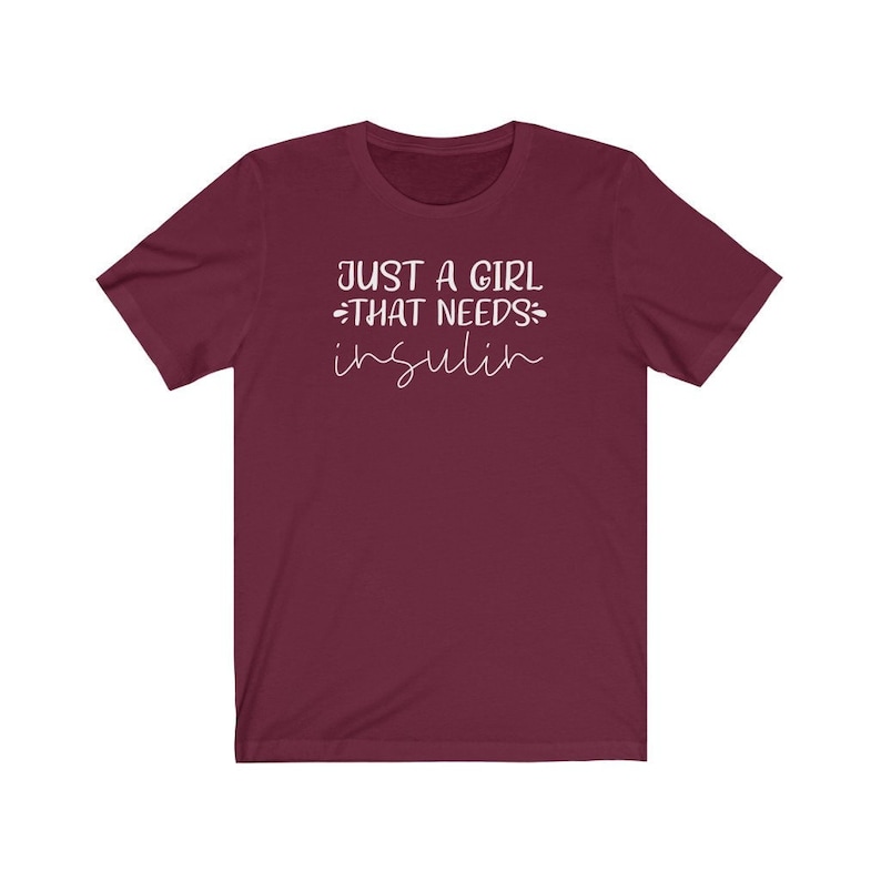 May include: Burgundy short-sleeved t-shirt with white text that reads "Just a girl that needs insulin".