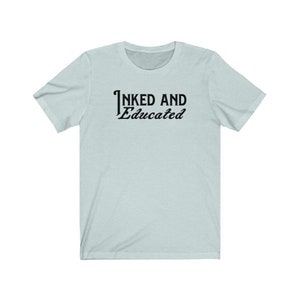 May include: A light blue t-shirt with the text "INKED AND Educated" printed in black on the front.