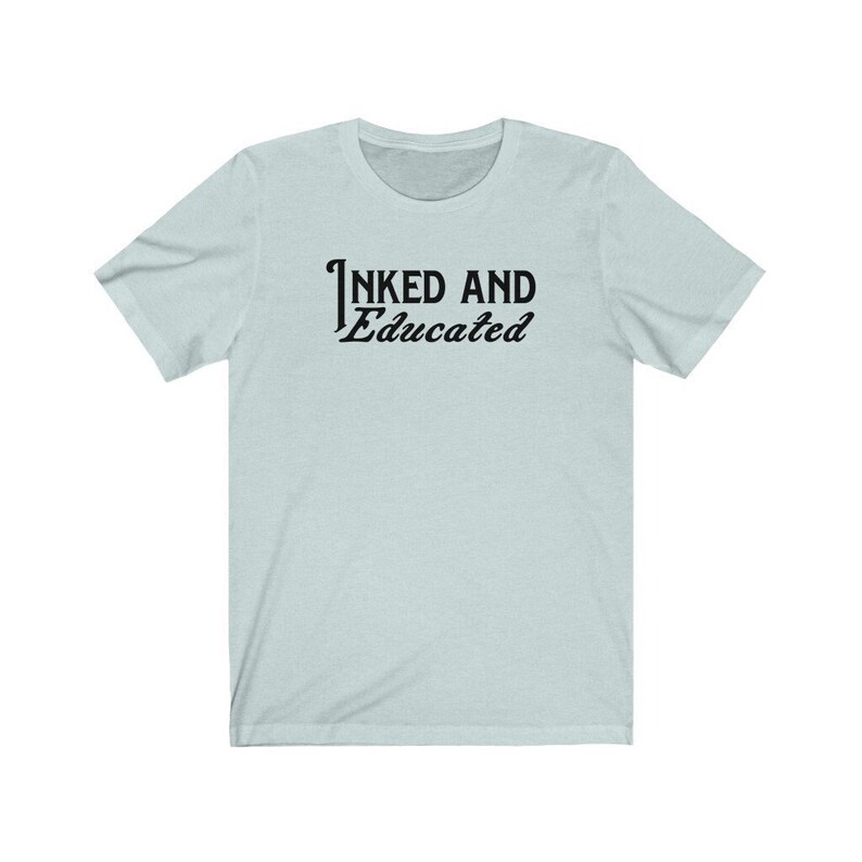 May include: A light blue t-shirt with the text "INKED AND Educated" printed in black on the front.