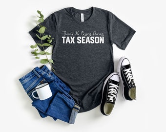 Puede incluir: Una camiseta gris oscuro jaspeada con el texto "There's No Crying During Tax Season" en letras blancas.